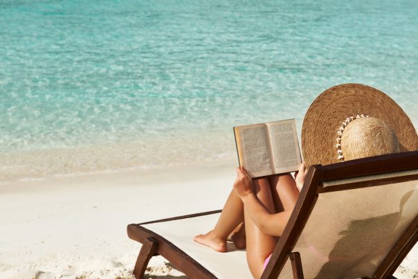 Young woman reading a book at the beach